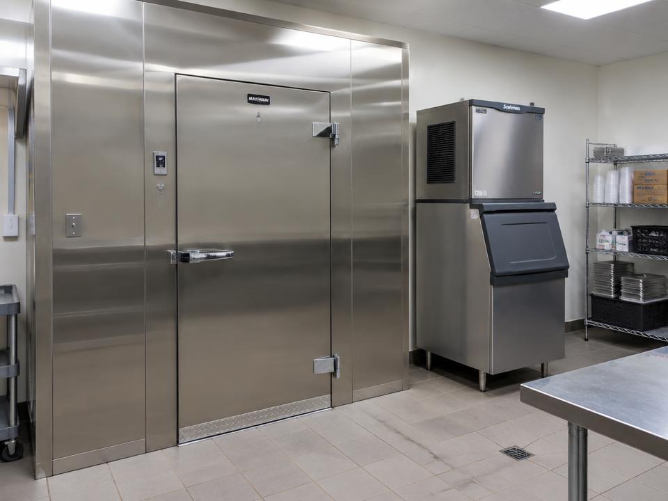 A stainless walk-in cooler beside a commercial ice machine